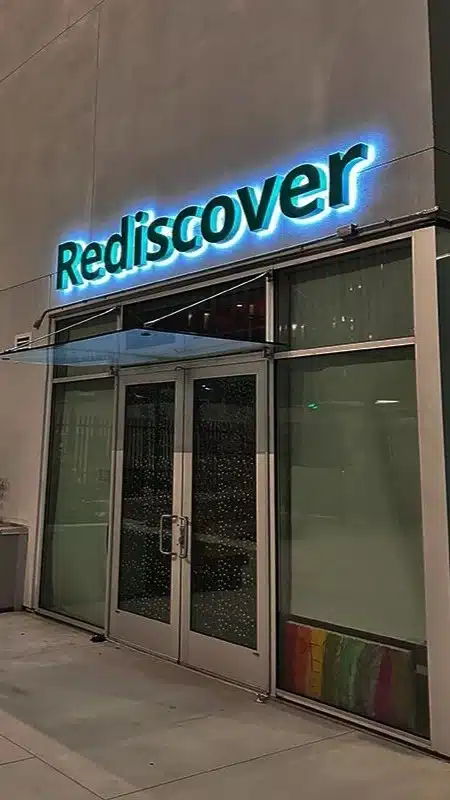 Custom Sign Design in Glendale, CA featuring a halo lit channel letter sign reading Rediscover on a storefront exterior at night.