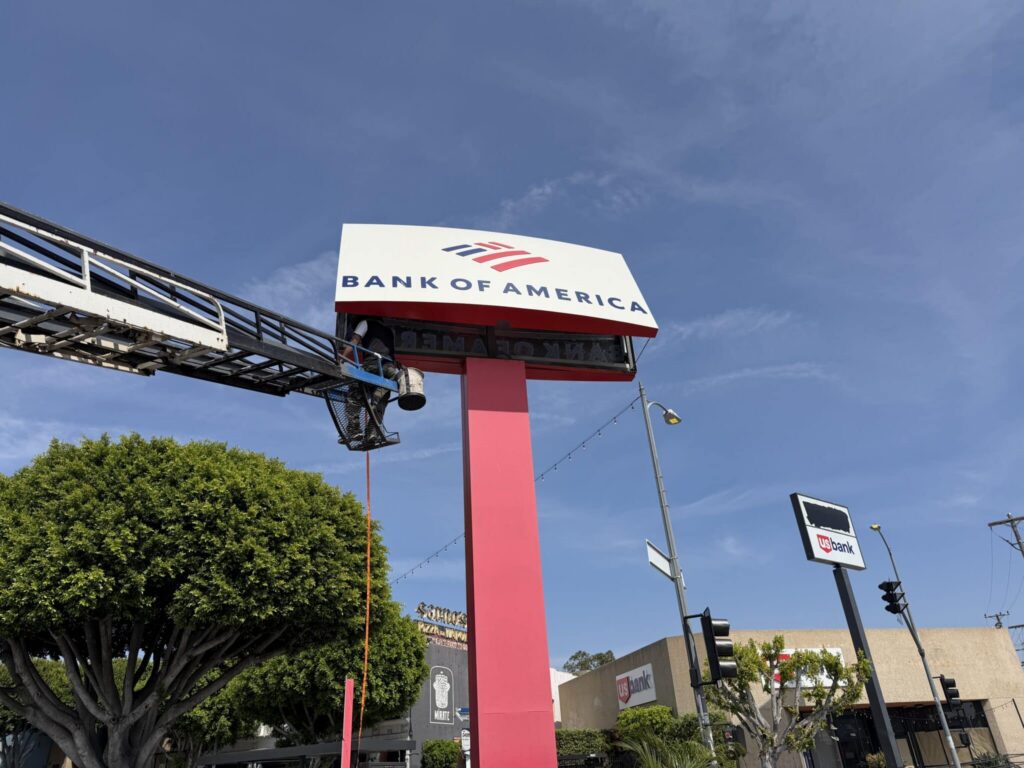 Sign installer on a boom lift servicing a Bank of America pylon sign in Venice, CA